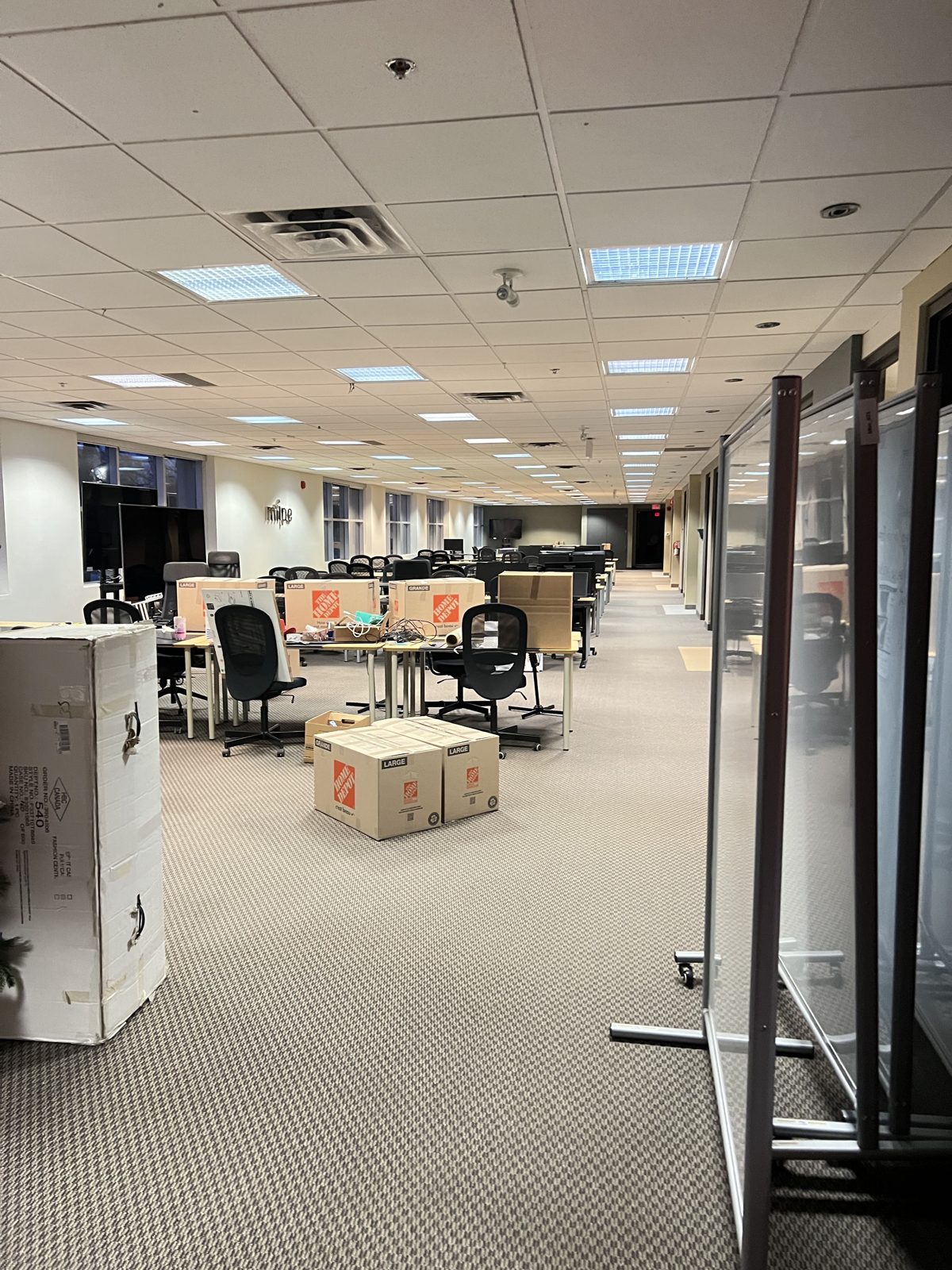 Office desks, cartons and lockers staged along a corridor ready for loading