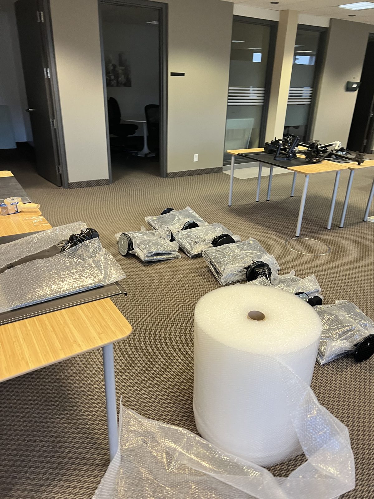 Bubble wrap roll and wrapped office equipment being packed for a commercial move