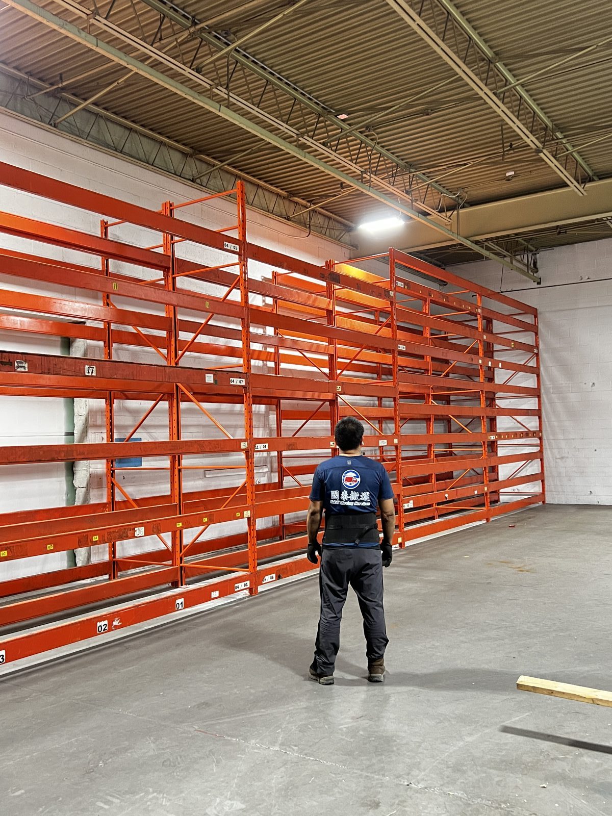 G&T worker standing in front of newly installed orange pallet racking in a warehouse